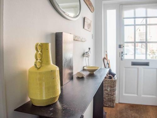 a yellow vase sitting on a counter in a kitchen at Honeybee Cottage, Orford in Orford
