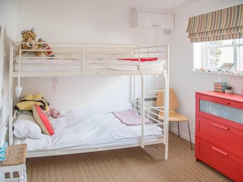 a bedroom with two bunk beds and a desk at Honeybee Cottage, Orford in Orford
