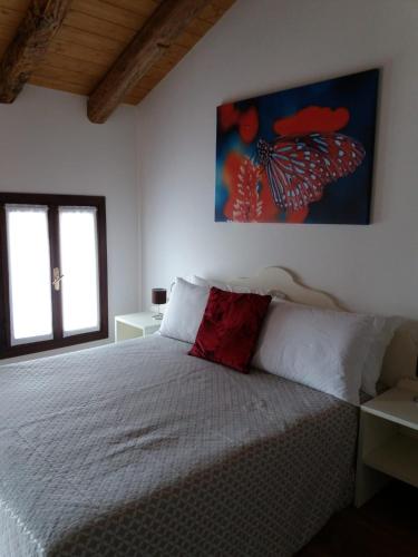 a bedroom with a white bed with a red pillow at LOCANDA RIGHETTO in Quinto di Treviso