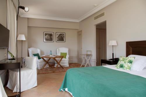 a bedroom with a bed and chairs and a table at Casa Anamaria Hotel in Ollers