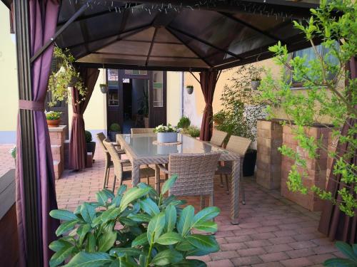 a patio with a table and chairs under an umbrella at Korzó Apartman in Kőszeg