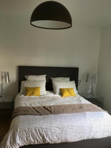 a bedroom with a large bed with yellow pillows at LOFT Le MARELLA in Royan