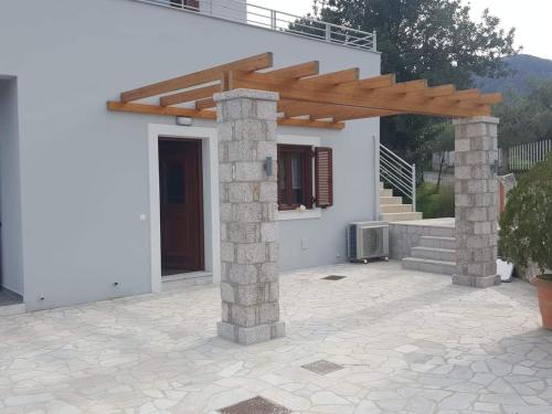 a house with a wooden pergola and a patio at Light blue house 1 in Poulithra