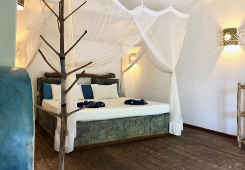 a bedroom with a bed with a canopy at Zanzistar Lodge in Jambiani