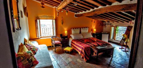 1 dormitorio con 1 cama y 1 sofá en una habitación en B&B Le Undici Lune, en San Gimignano