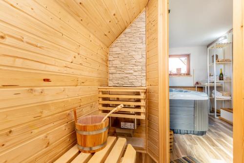 sauna con pared de madera y bañera en Kuća za odmor Villa.ris en Lokve