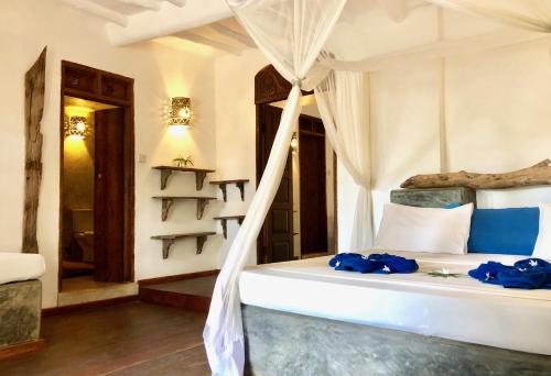 a bedroom with a bed with blue towels on it at Zanzistar Lodge in Jambiani
