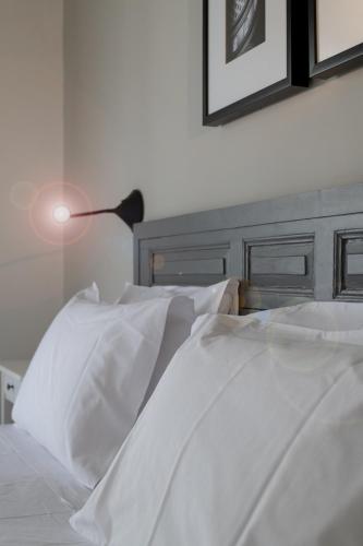a bed with white sheets and a lamp on it at Chapter 5 Hotel in Taʼ Xbiex