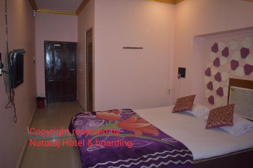 BarddhamānにあるNataraj Hotel and Boardingのベッドルーム(紫の毛布を使用した大型ベッド1台付)