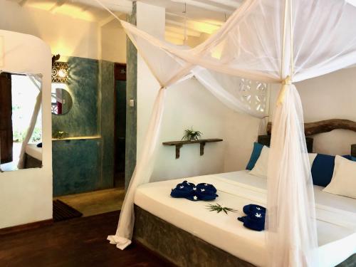 a bedroom with a bed with a canopy at Zanzistar Lodge in Jambiani