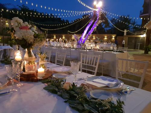 a table set up for a wedding with lights and candles at Leano Agriresort in Piazza Armerina