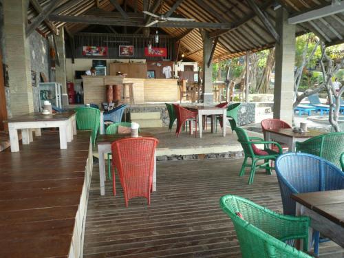 a restaurant with green chairs and tables and tables and chairs at Wawa Wewe II Villas in Amed