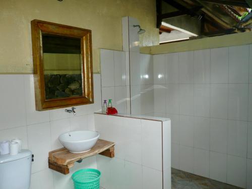 a white bathroom with a sink and a mirror at Wawa Wewe II Villas in Amed