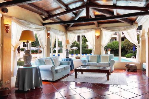 a living room filled with furniture and a large window at Colonna Park Hotel in Porto Cervo