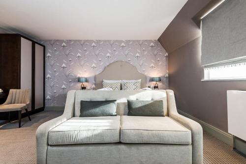 a bedroom with a bed and a couch at Edgbaston Park Hotel Birmingham in Birmingham
