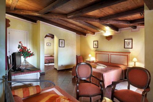 a bedroom with a bed and chairs in a room at Colonna Park Hotel in Porto Cervo