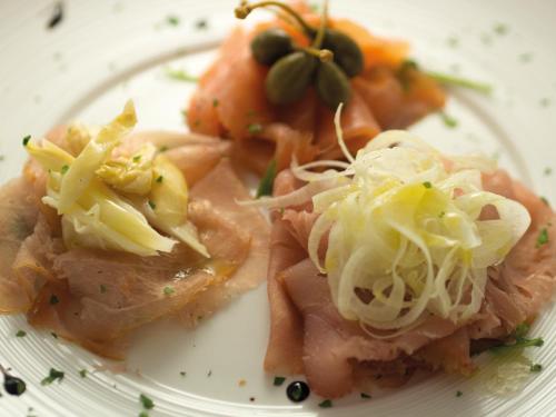 a plate of food with meat and vegetables on it at Hotel Victoria in Vicenza