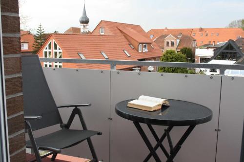 einen Tisch und einen Stuhl auf einem Balkon mit Aussicht in der Unterkunft Ferienwohnung Perlmutt in Hooksiel