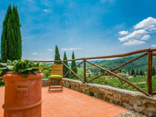 a chair and a potted plant sitting on a patio at Holiday Home La Corte by Interhome in Lucolena in Chianti