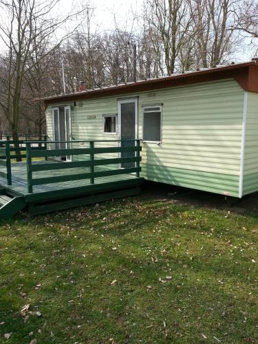 a green and white house with a porch at Marina Týnec n. L. - Kemp in Týnec nad Labem