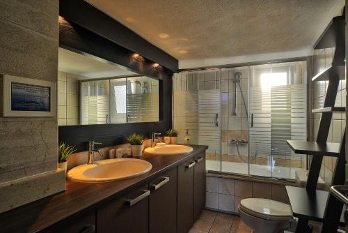 a bathroom with two sinks and a shower at Bella Vista Villas & Suites in Gaios