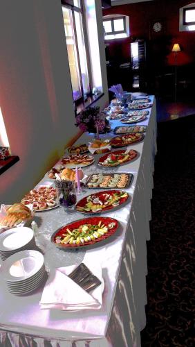 a long table with many plates of food on it at Rooms Villa Iva in Ilok