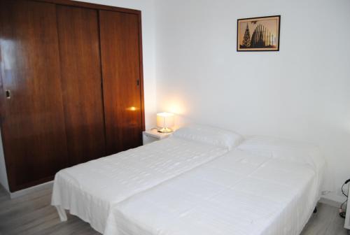 a bedroom with two white beds and a wooden door at Legroux - 373 in Llafranc