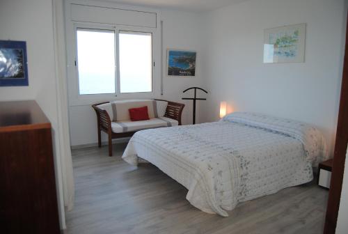 a bedroom with a bed and a chair and a window at Legroux - 373 in Llafranc
