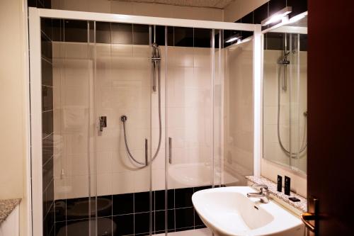 a bathroom with a shower and a sink and a sink at JR Hotels Bologna Amadeus in Bologna