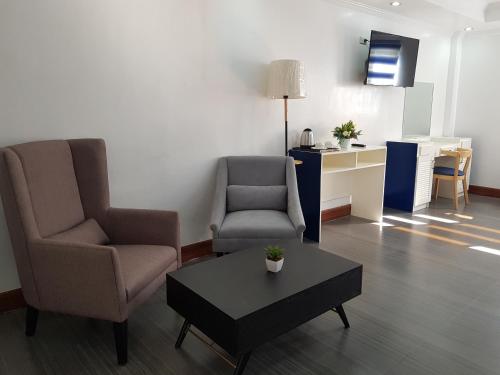a living room with two chairs and a coffee table at Santiago Cove Hotel and Restaurant in Santiago