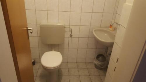 a white toilet sitting next to a white sink at GZ Hostel Bonn in Bonn