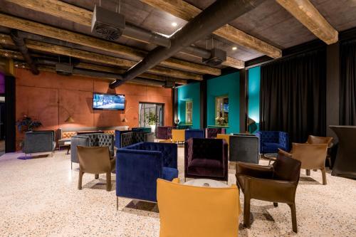 a room with chairs and tables and a television at Winery & Design hotel ROXANICH in Motovun