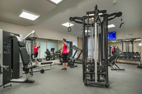 a woman is standing in a gym with weights at Grand Hotel Pietra Ligure in Pietra Ligure