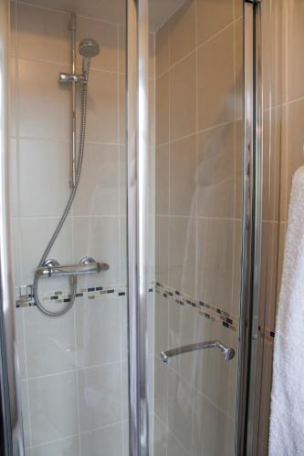 a shower with a glass door in a bathroom at Amberley Inn in Stroud