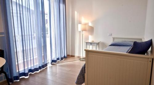 a bedroom with a bed and large windows at Petit Hotel in Lido di Camaiore