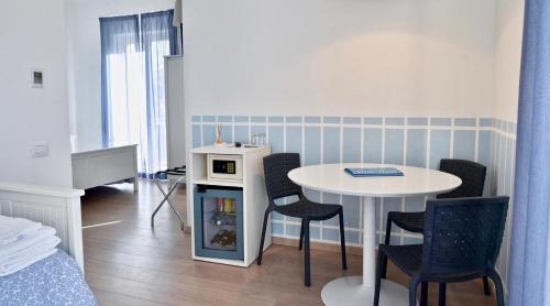 a small room with a table and chairs and a bed at Petit Hotel in Lido di Camaiore