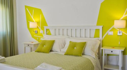 a bedroom with a bed with green and white pillows at Petit Hotel in Lido di Camaiore