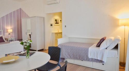 a bedroom with a bed and a table and chairs at Petit Hotel in Lido di Camaiore