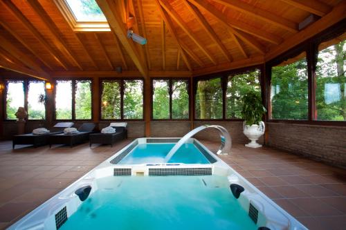 une baignoire jacuzzi dans une maison avec toit dans l'établissement Hotel & Spa Etxegana, à Zeanuri