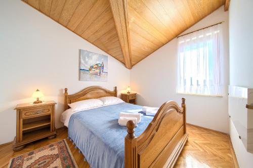 a bedroom with a bed and a wooden ceiling at Apartment Galerija by El-Pi Tours in Njivice