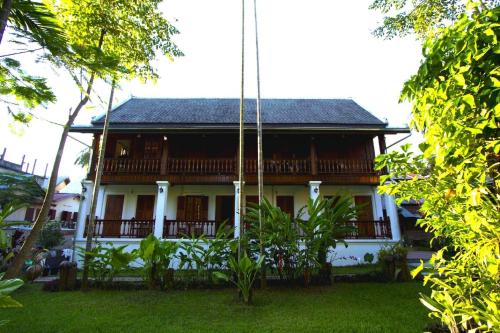 a white house with a gambrel roof at Villa Chitdara in Luang Prabang