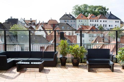 a balcony with a couch and chairs and a city at Comfort Hotel Bergen in Bergen