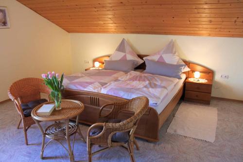 1 dormitorio con 1 cama, mesa y sillas en Ferienwohnung Cornelia Frisch en Sankt Oswald