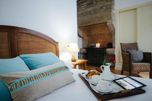 a bedroom with a bed with a tray with a trayasteryasteryasteryasteryastery at Hotel Arco de Mazarelos in Santiago de Compostela