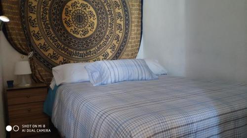 um quarto com uma cama com um cobertor e uma parede em Apacos muy cerca playa Entrada Autónoma em Algarrobo