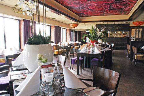 een restaurant met tafels en stoelen en een rood plafond bij Fletcher Hotel - Restaurant Heiloo in Heiloo