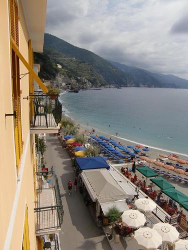 a view of a beach with umbrellas and the ocean at Hotel La Spiaggia in Monterosso al Mare