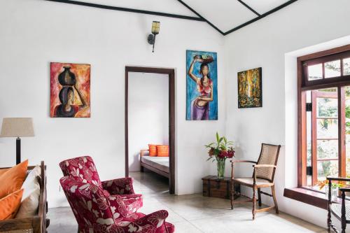 a living room with two chairs and a mirror at Rosyth Estate House in Pinnawala