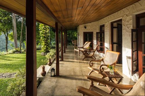 a porch with rocking chairs on a house at Rosyth Estate House in Pinnawala