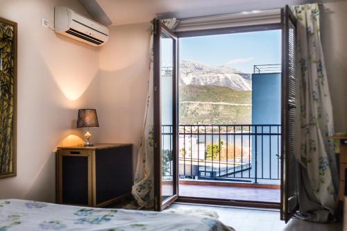 um quarto com uma porta que abre para uma varanda em Villa Danile Cosy Apartments em Budva